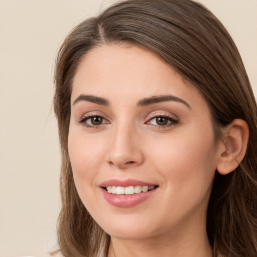 Joyful white young-adult female with long  brown hair and brown eyes