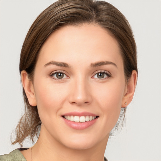 Joyful white young-adult female with medium  brown hair and grey eyes