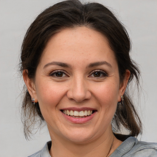 Joyful white young-adult female with medium  brown hair and brown eyes