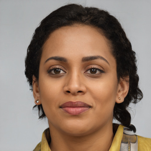 Joyful black young-adult female with medium  brown hair and brown eyes