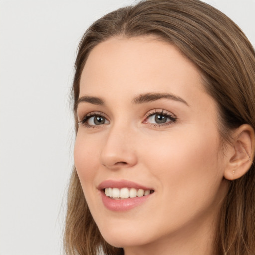 Joyful white young-adult female with long  brown hair and green eyes