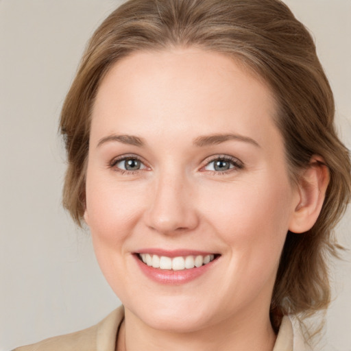 Joyful white young-adult female with medium  brown hair and grey eyes