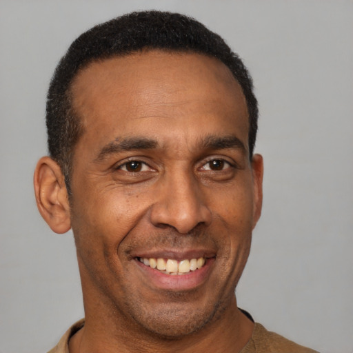 Joyful latino adult male with short  brown hair and brown eyes