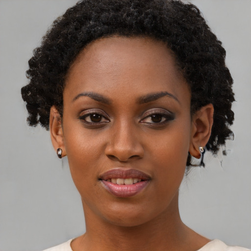 Joyful black young-adult female with short  black hair and brown eyes