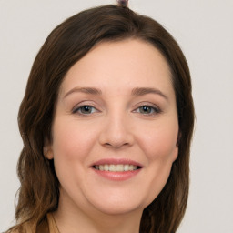 Joyful white young-adult female with long  brown hair and grey eyes