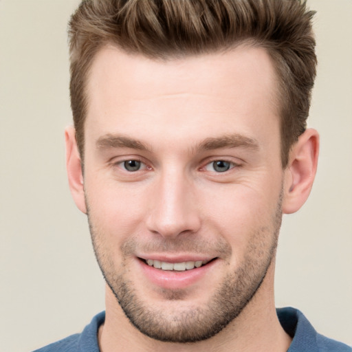 Joyful white young-adult male with short  brown hair and grey eyes