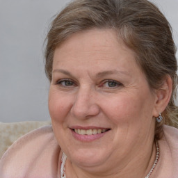 Joyful white adult female with medium  brown hair and blue eyes