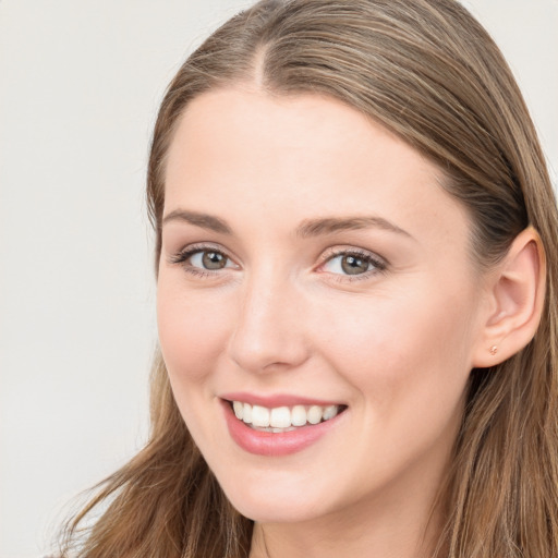 Joyful white young-adult female with long  brown hair and blue eyes