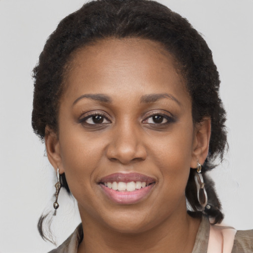 Joyful black young-adult female with long  brown hair and brown eyes