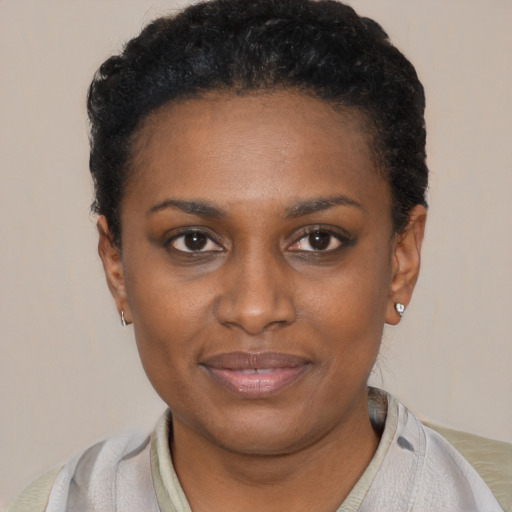 Joyful black young-adult female with short  black hair and brown eyes