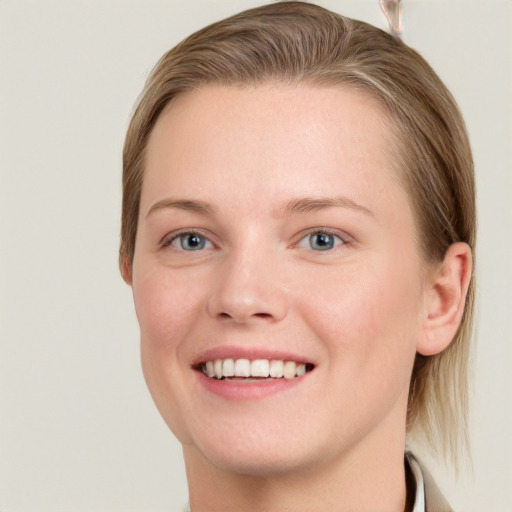 Joyful white young-adult female with medium  brown hair and blue eyes