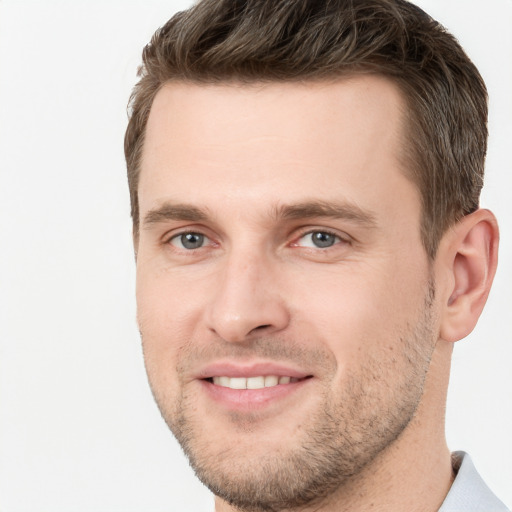 Joyful white young-adult male with short  brown hair and grey eyes