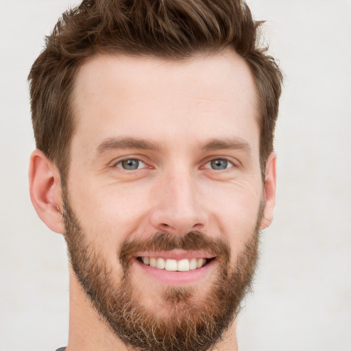 Joyful white young-adult male with short  brown hair and grey eyes