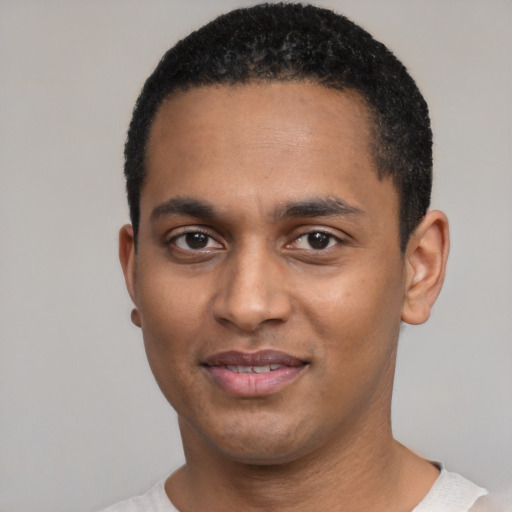 Joyful black young-adult male with short  black hair and brown eyes