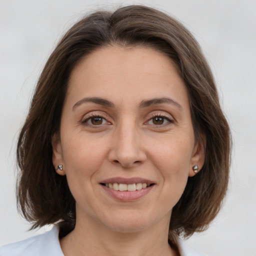 Joyful white adult female with medium  brown hair and brown eyes