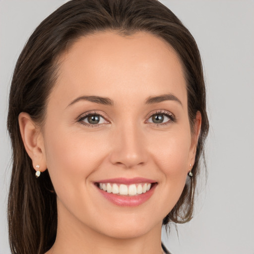 Joyful white young-adult female with long  brown hair and brown eyes