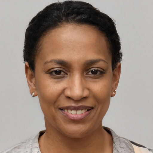 Joyful black young-adult female with short  black hair and brown eyes