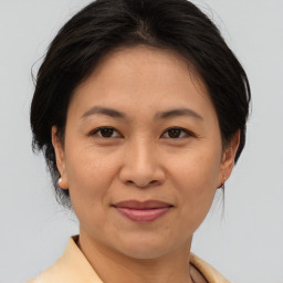 Joyful asian adult female with medium  brown hair and brown eyes