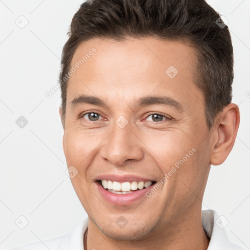 Joyful white young-adult male with short  brown hair and brown eyes