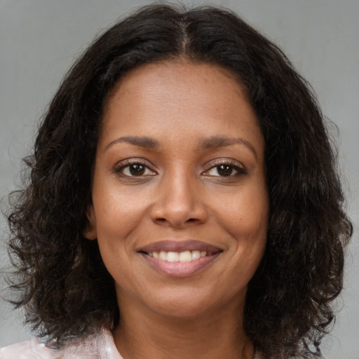Joyful black young-adult female with medium  brown hair and brown eyes