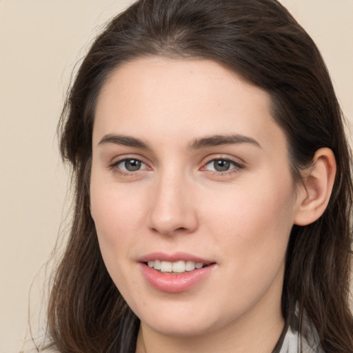 Joyful white young-adult female with long  brown hair and brown eyes