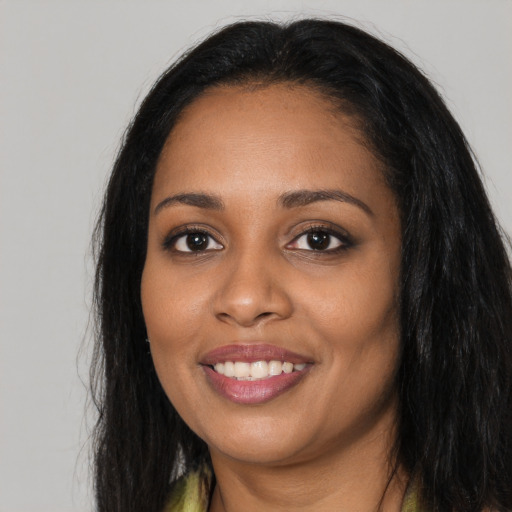 Joyful black young-adult female with long  black hair and brown eyes
