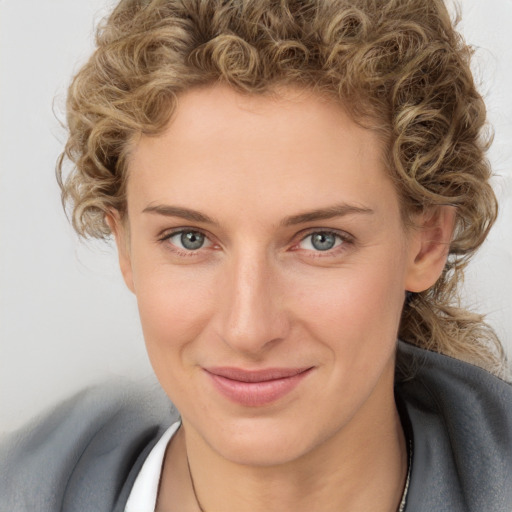 Joyful white young-adult female with short  brown hair and blue eyes