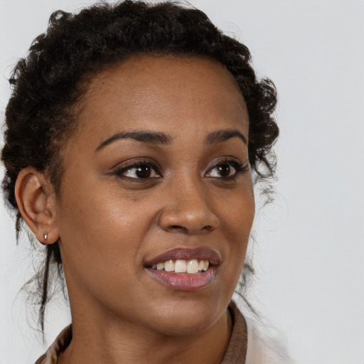 Joyful black young-adult female with long  brown hair and brown eyes