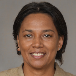 Joyful latino adult female with medium  brown hair and brown eyes