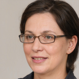 Joyful white adult female with medium  brown hair and grey eyes