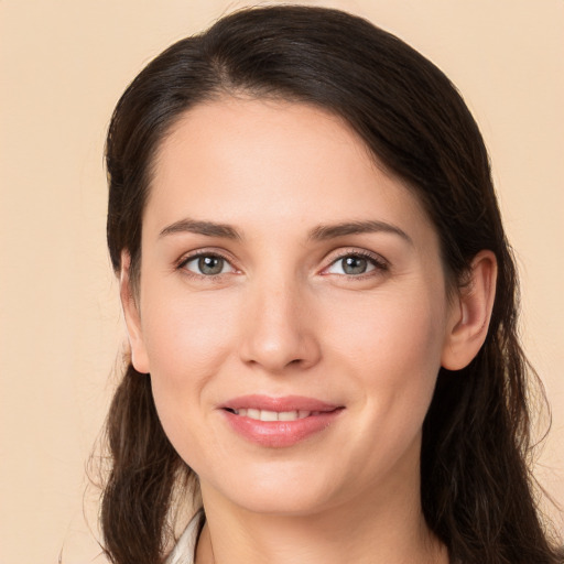 Joyful white young-adult female with long  brown hair and brown eyes