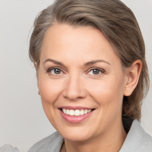 Joyful white adult female with medium  brown hair and brown eyes