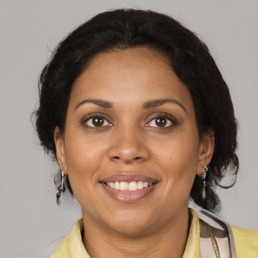Joyful black adult female with medium  brown hair and brown eyes