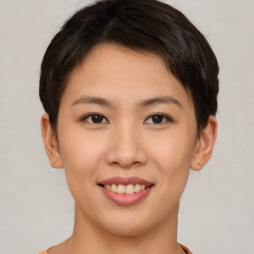 Joyful asian young-adult female with short  brown hair and brown eyes
