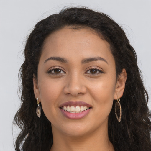 Joyful latino young-adult female with long  brown hair and brown eyes