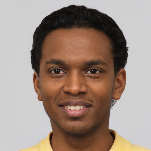 Joyful black young-adult male with short  black hair and brown eyes