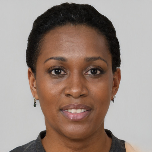 Joyful black young-adult female with short  black hair and brown eyes