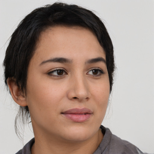 Joyful latino young-adult female with medium  brown hair and brown eyes