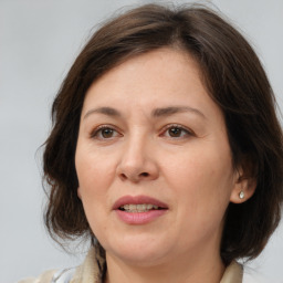 Joyful white adult female with medium  brown hair and brown eyes