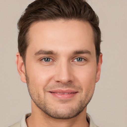 Joyful white young-adult male with short  brown hair and grey eyes