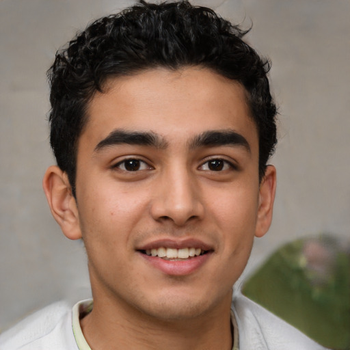 Joyful latino young-adult male with short  brown hair and brown eyes