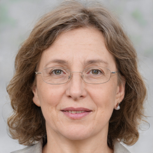 Joyful white adult female with medium  brown hair and blue eyes