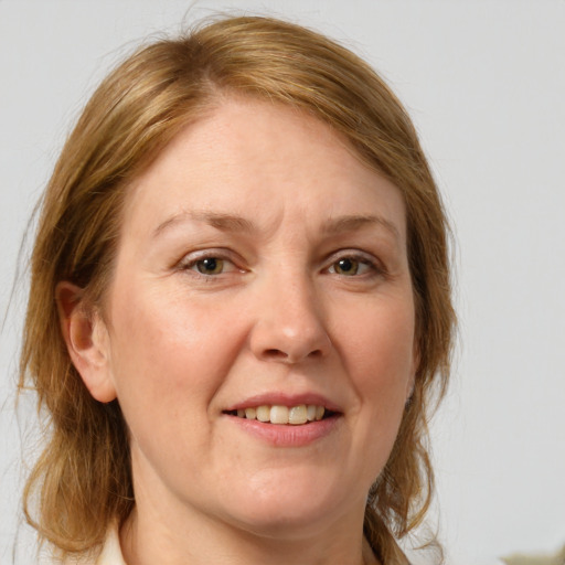 Joyful white adult female with medium  brown hair and grey eyes