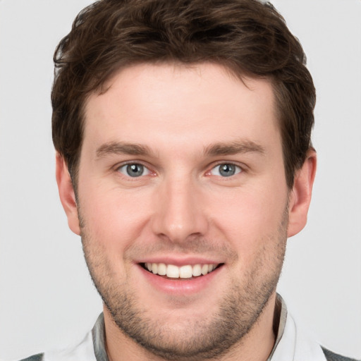 Joyful white young-adult male with short  brown hair and grey eyes