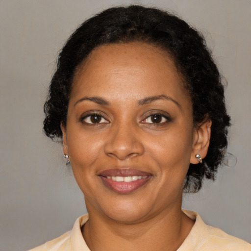 Joyful black adult female with medium  black hair and brown eyes
