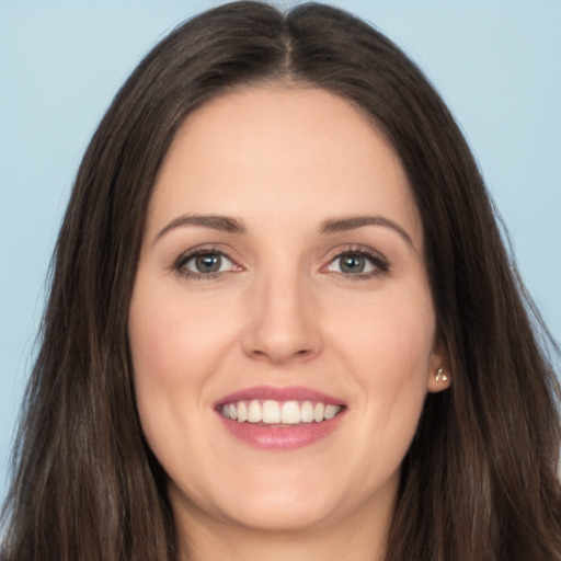 Joyful white young-adult female with long  brown hair and brown eyes