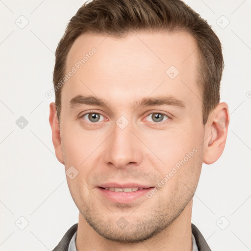 Joyful white young-adult male with short  brown hair and grey eyes