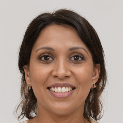 Joyful latino young-adult female with medium  brown hair and brown eyes