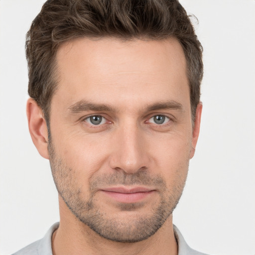 Joyful white young-adult male with short  brown hair and grey eyes