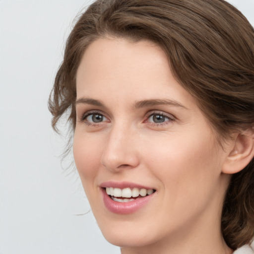 Joyful white young-adult female with medium  brown hair and green eyes